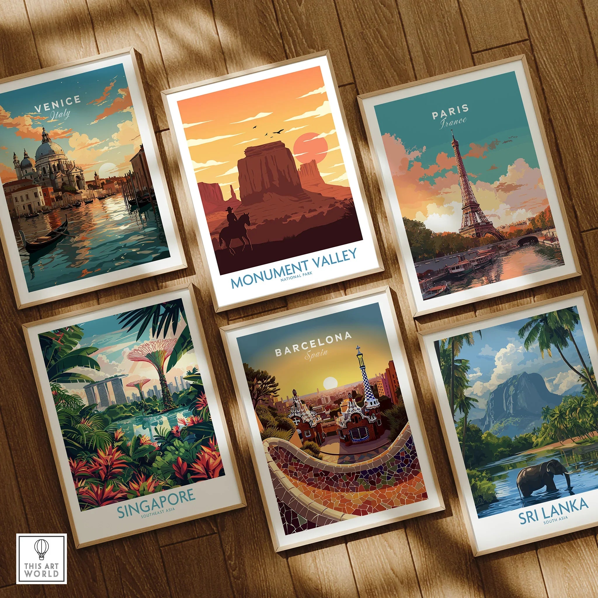 Set of six framed travel posters featuring Venice, Monument Valley, Paris, Singapore, Barcelona, and Sri Lanka on a wooden floor.