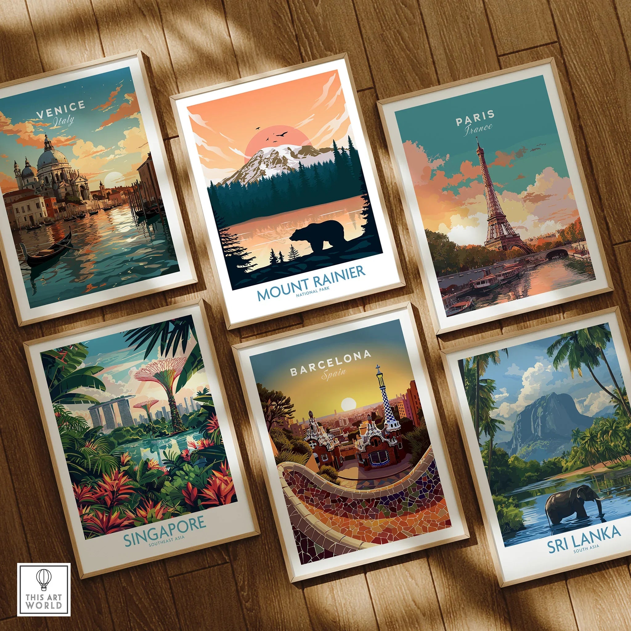 Set of six framed travel posters featuring Venice, Mount Rainier, Paris, Singapore, Barcelona, and Sri Lanka on a wooden floor.