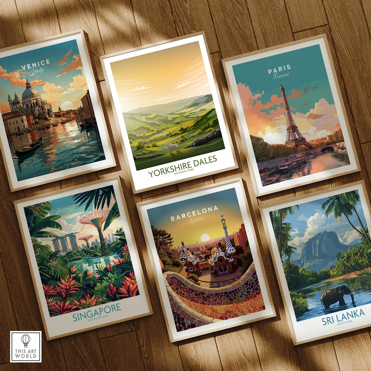 Set of six framed travel posters featuring Venice, Yorkshire Dales, Paris, Singapore, Barcelona, and Sri Lanka on a wooden floor.