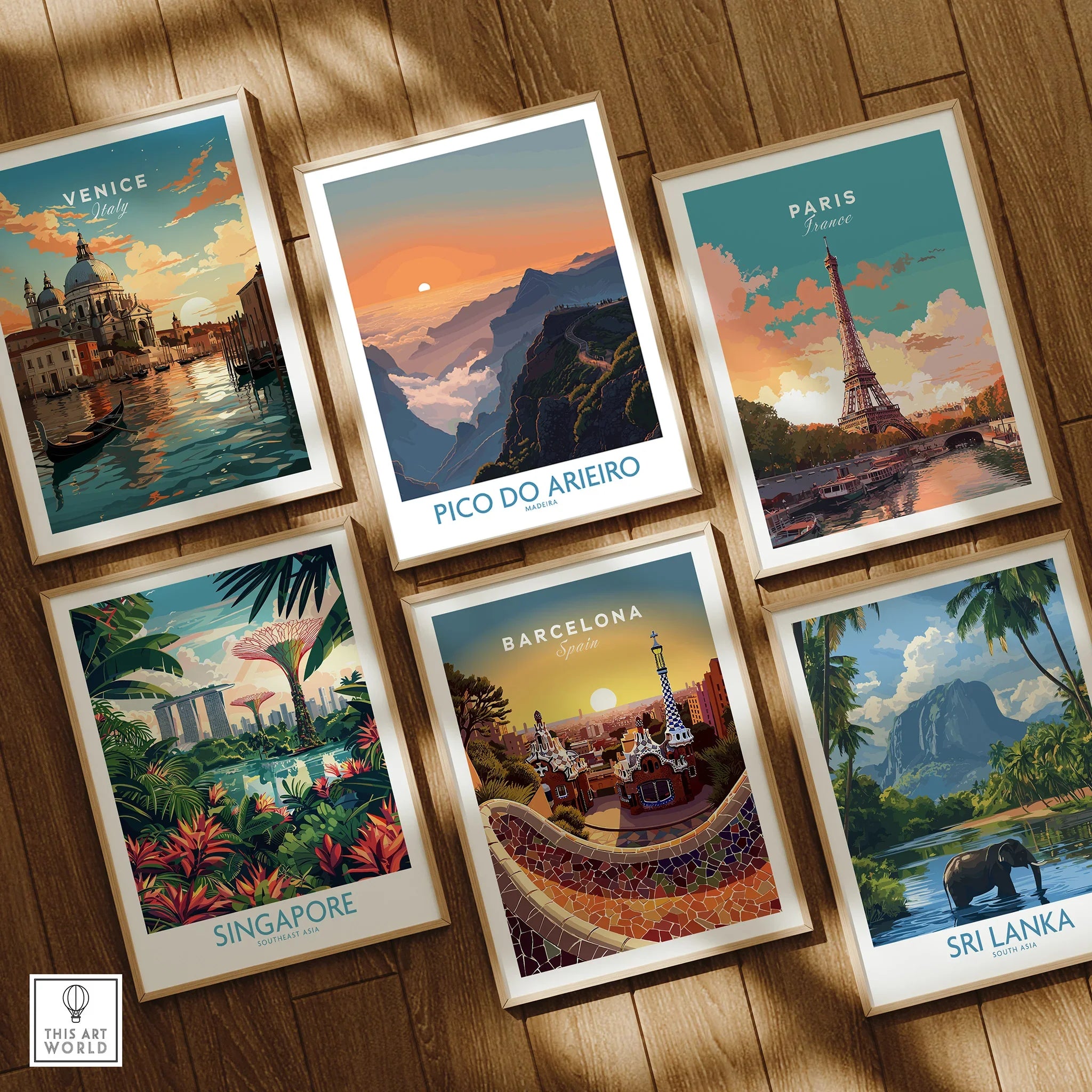 Set of six framed travel posters featuring Venice, Pico do Arieiro, Paris, Singapore, Barcelona, and Sri Lanka on a wooden floor.