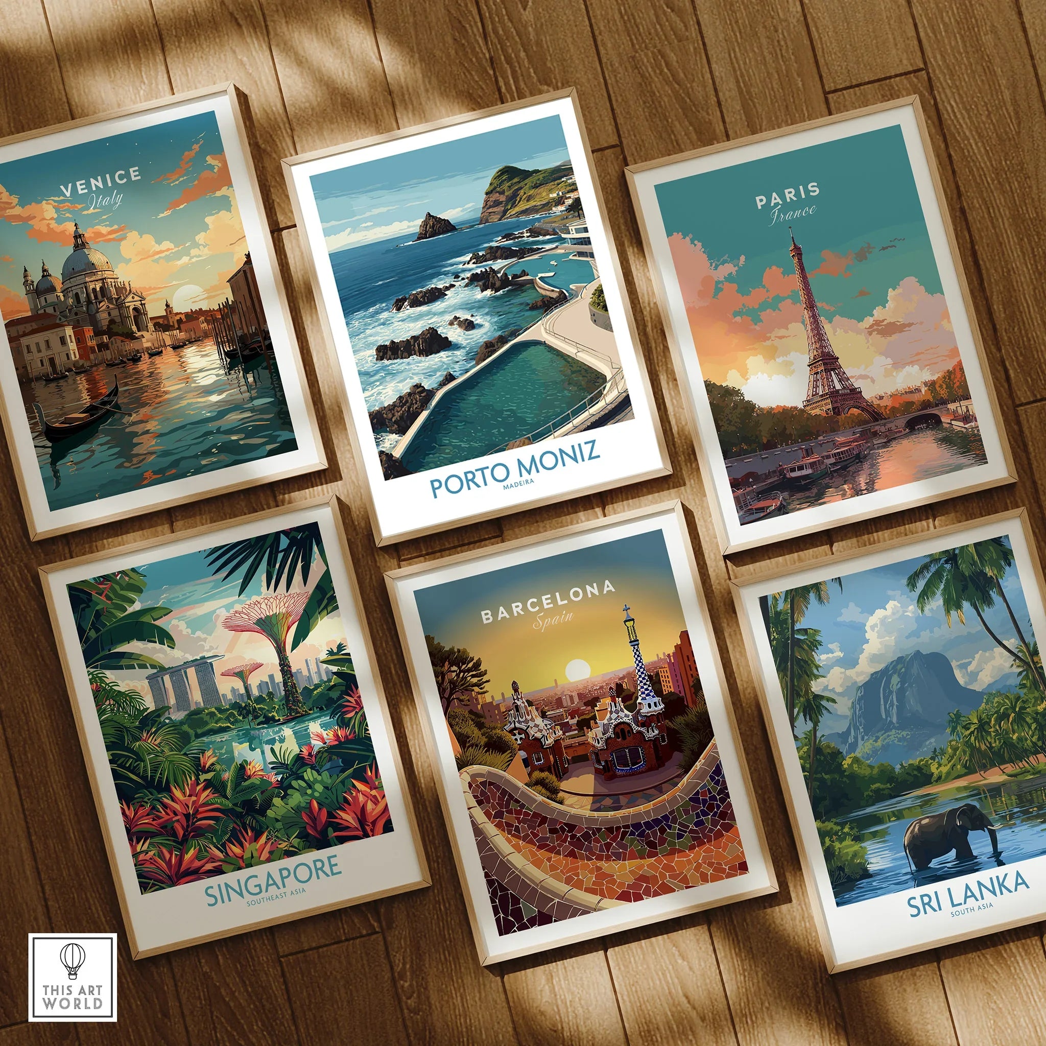Set of six framed travel posters featuring Venice, Porto Moniz, Paris, Singapore, Barcelona, Sri Lanka on a wooden floor.