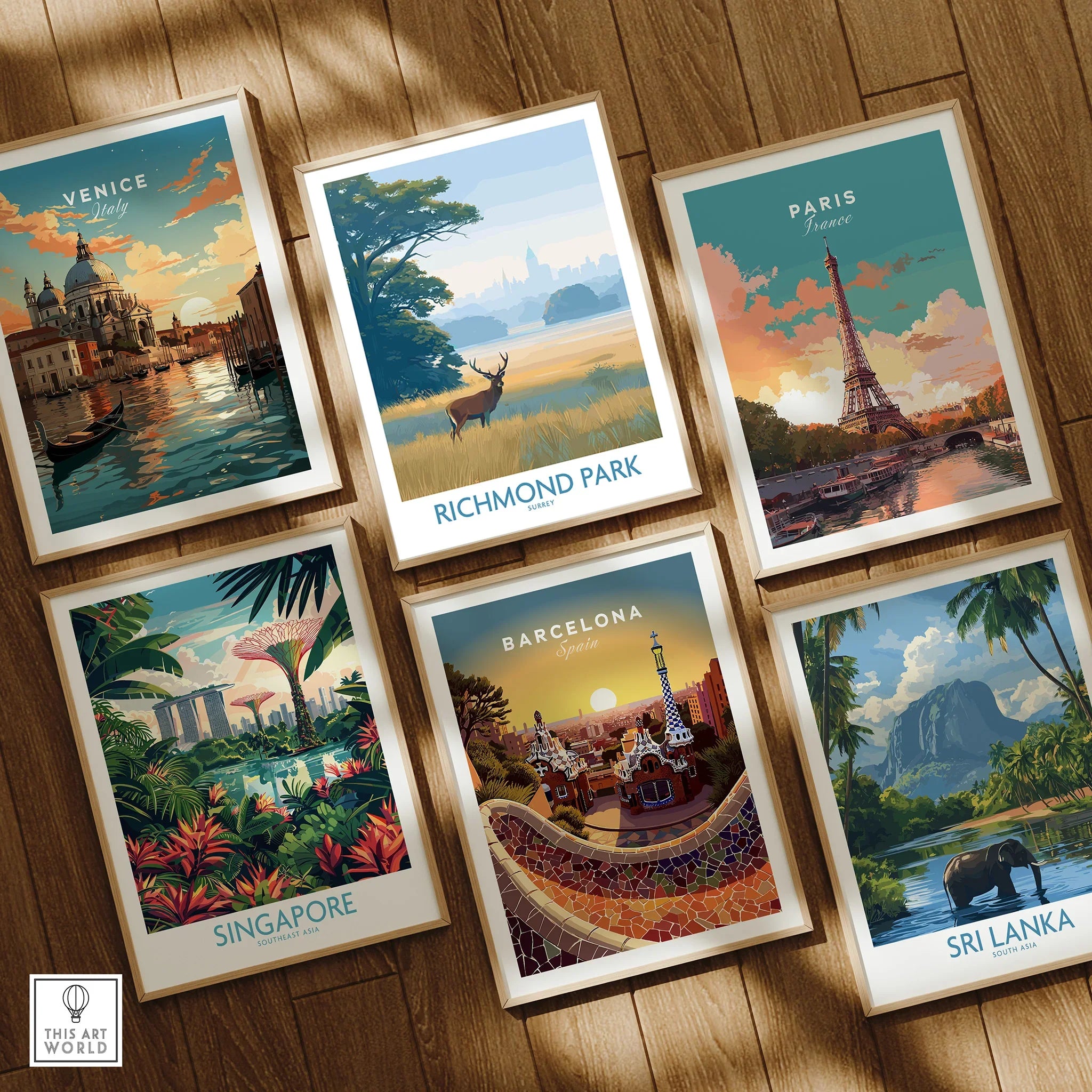 Set of six framed travel posters featuring Venice, Richmond Park, Paris, Singapore, Barcelona, and Sri Lanka on a wooden floor.