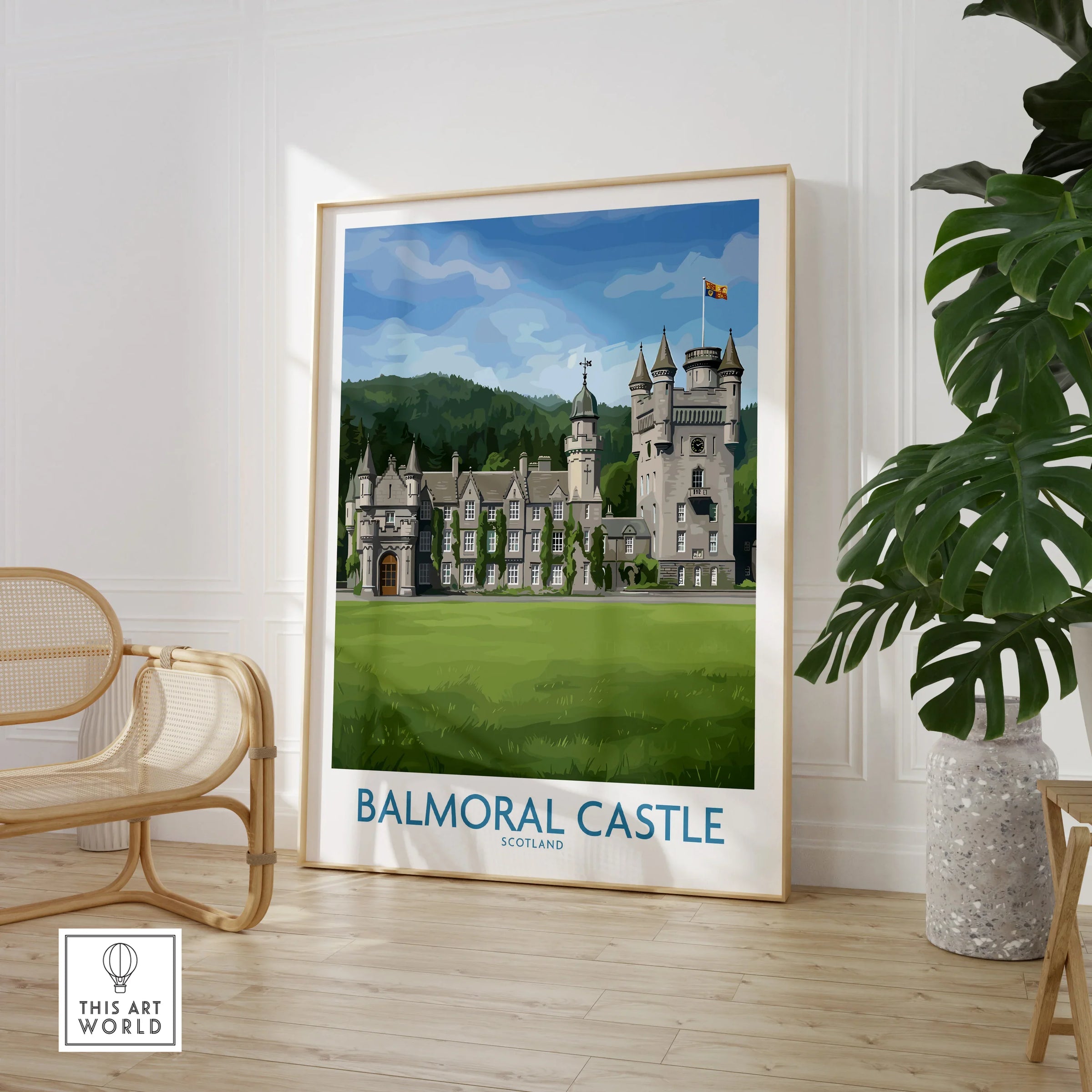 Framed Balmoral Castle Scotland travel poster in modern room with chair and plant