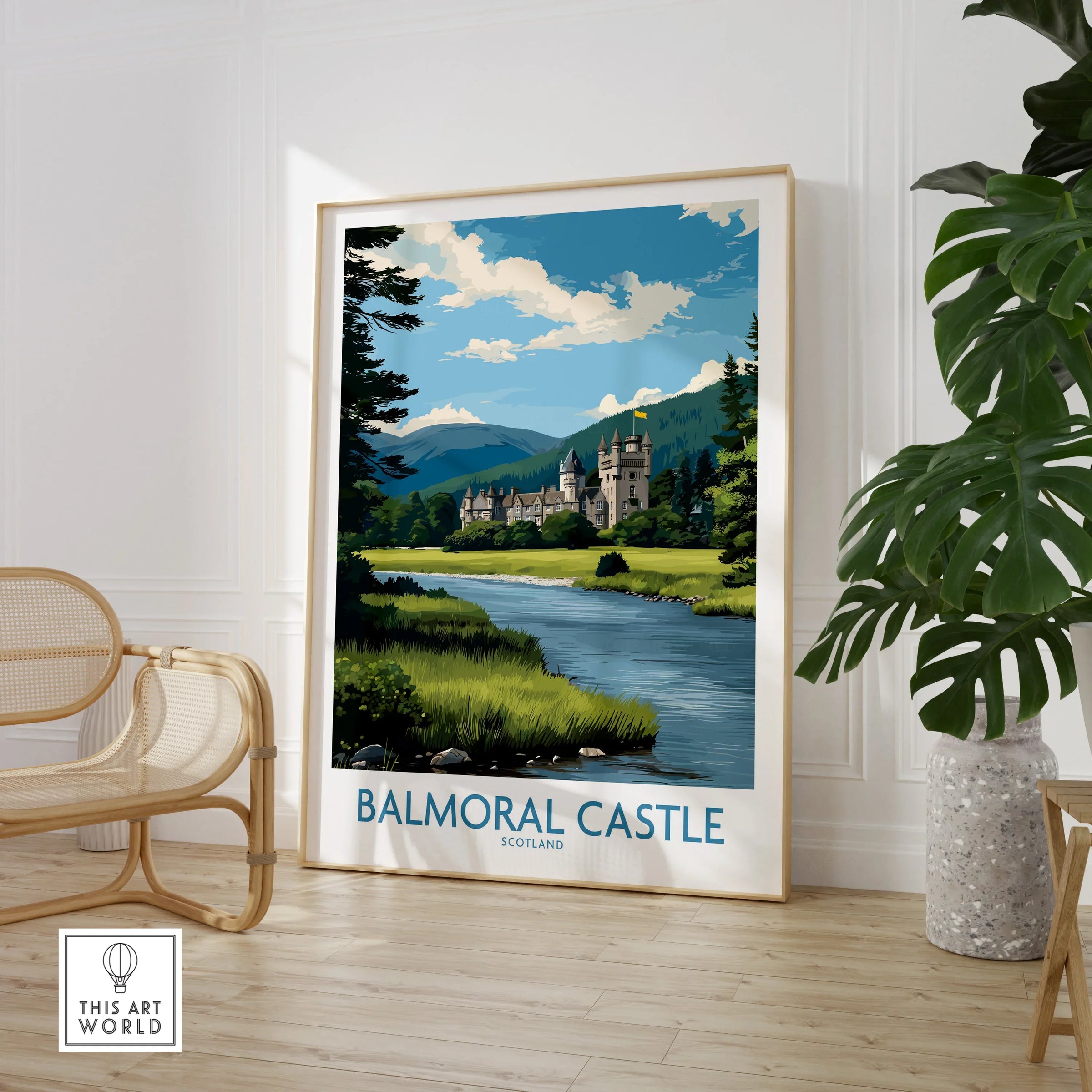 Framed Balmoral Castle travel poster with scenic landscape in modern living room setting.