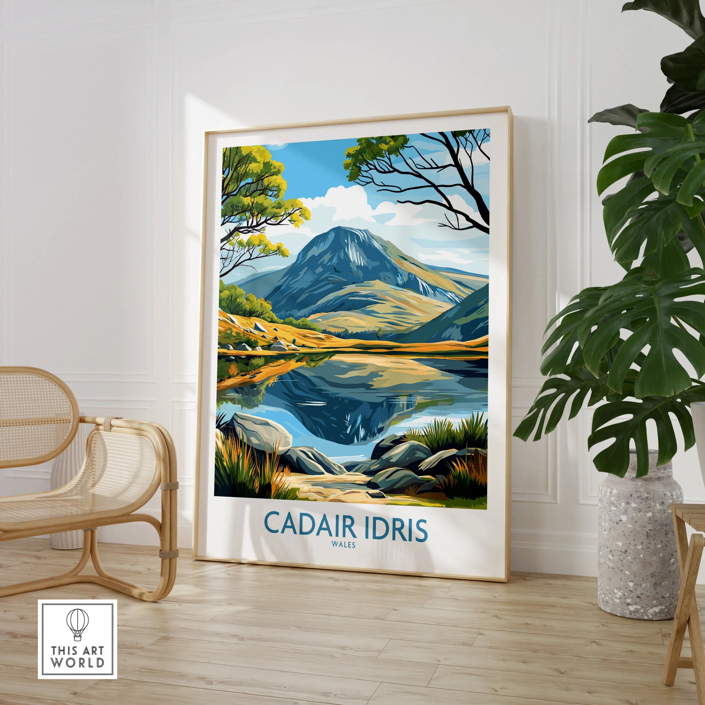 Framed Cadair Idris Wales travel poster in modern room with chair and large plant