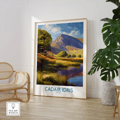 Framed Cadair Idris travel poster print in modern room with chair and plant, mountain landscape art