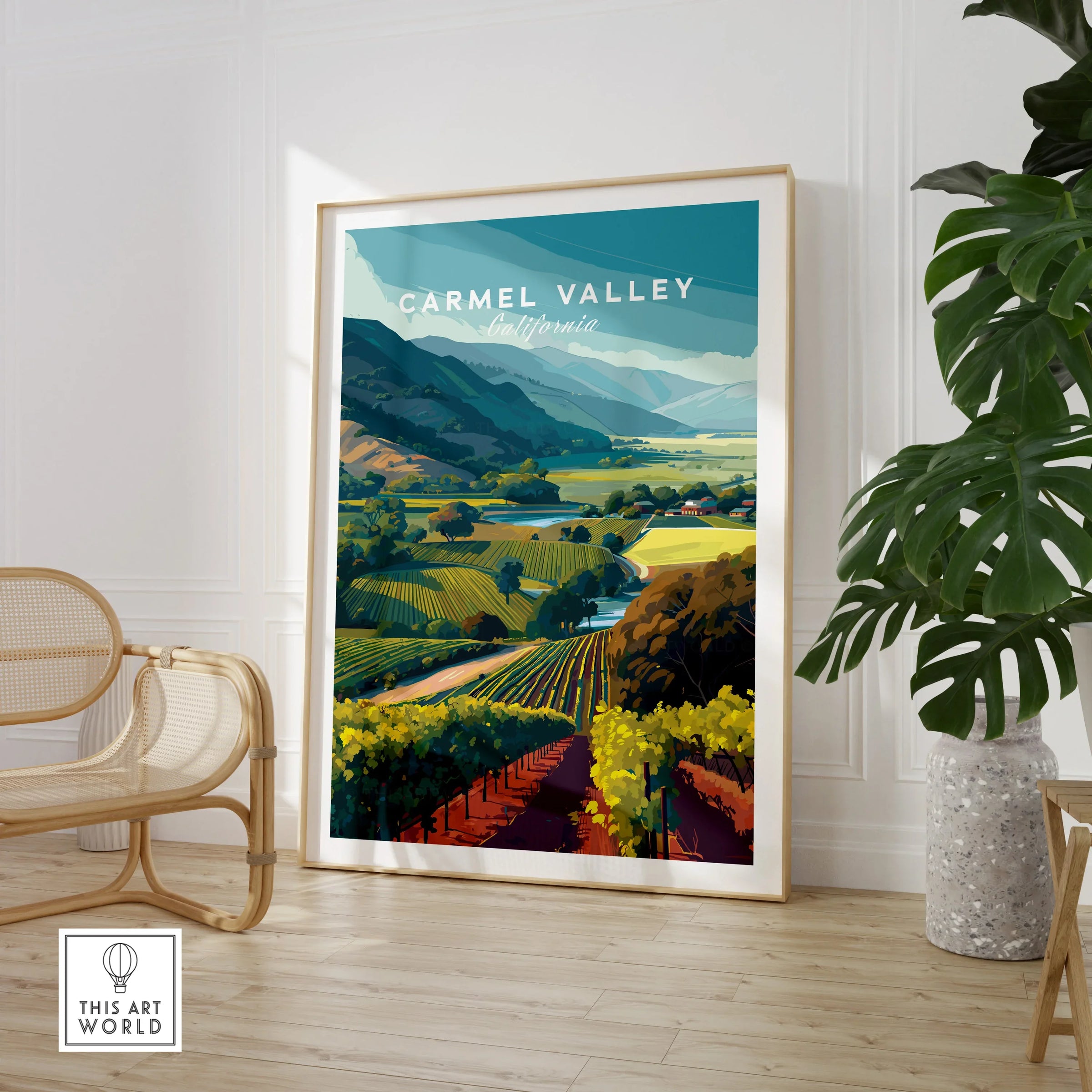Framed Carmel Valley California travel poster art in modern room with chair and plant