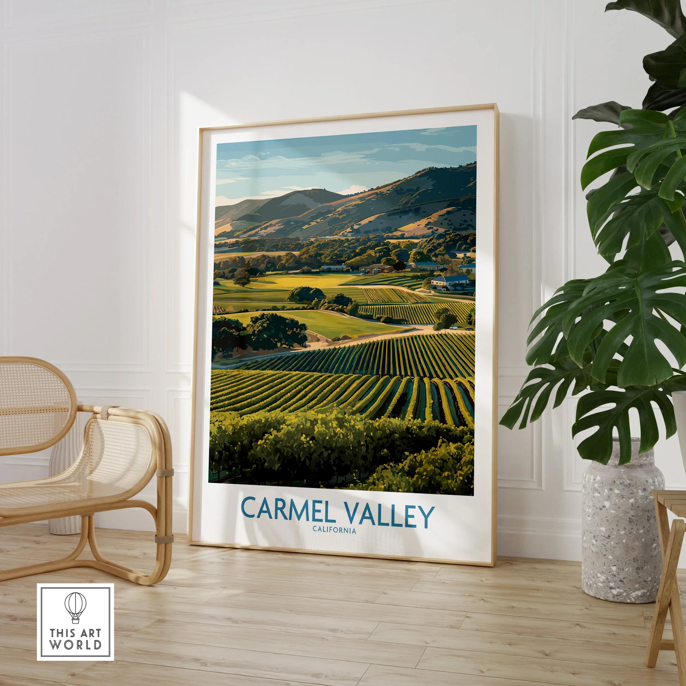 Framed Carmel Valley California travel poster in modern room with chair and green plant