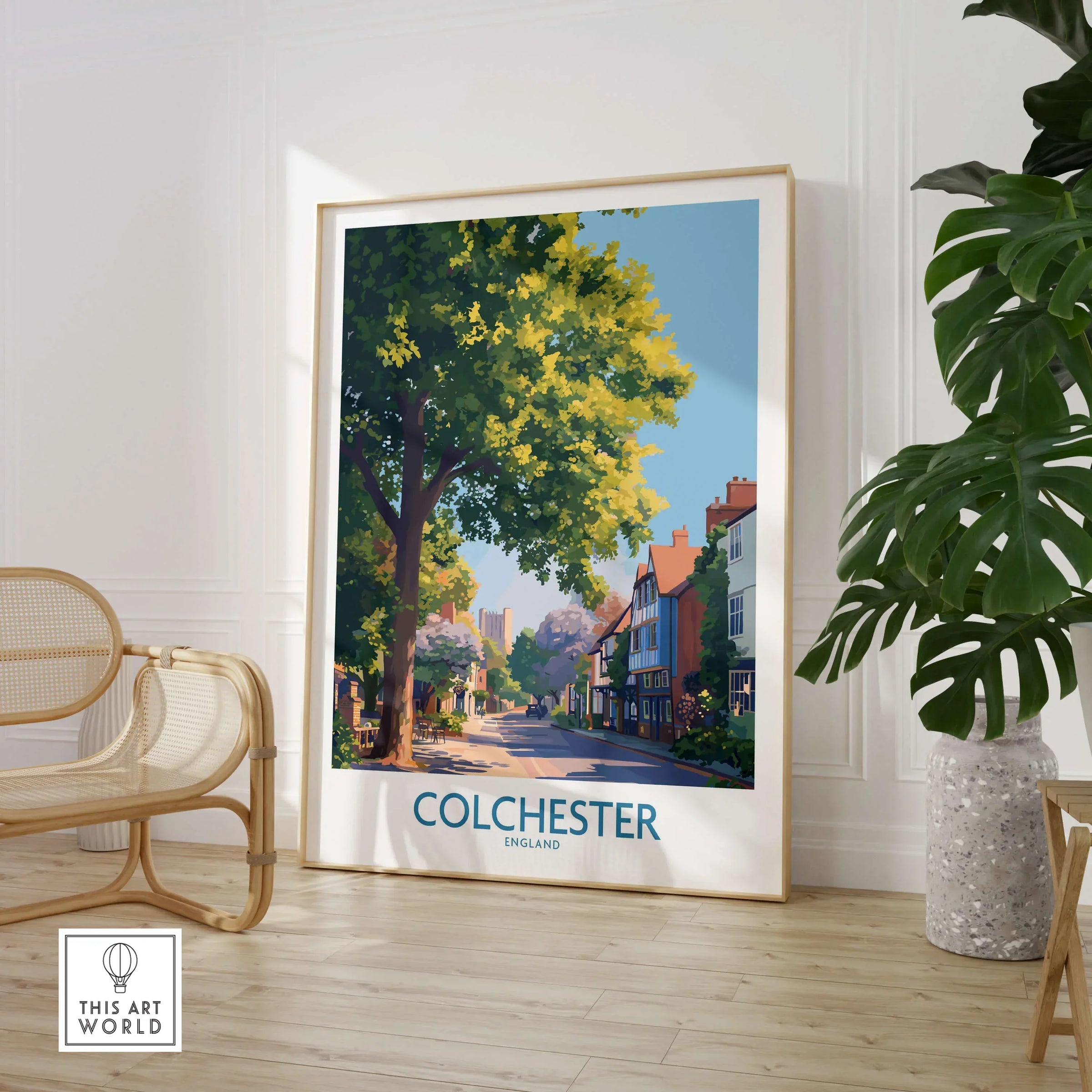 Colchester England travel poster framed on floor in modern room with chair and plant