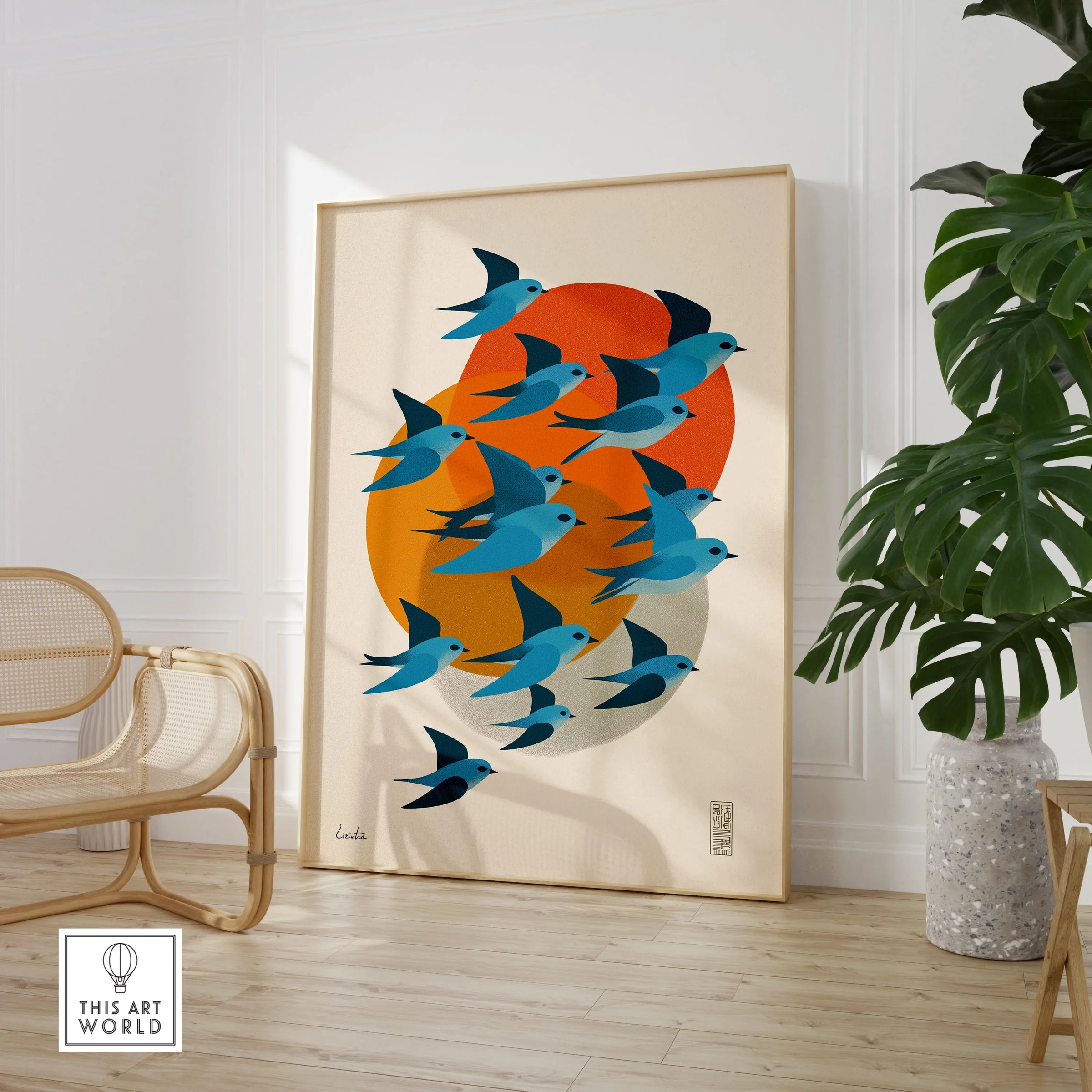 Framed Japanese birds art print with orange sun in modern living room with chair and plant