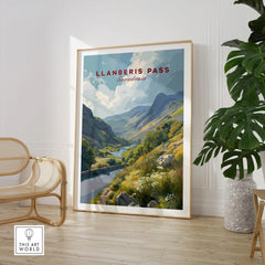 Framed Llanberis Pass Snowdonia travel print in modern room with chair and houseplant