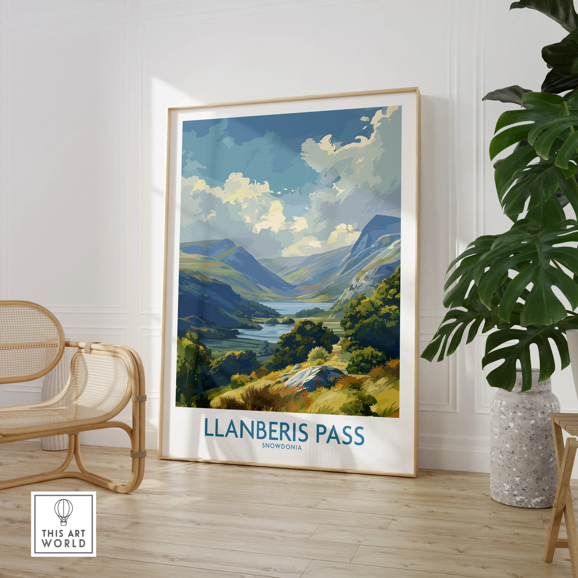 Framed Llanberis Pass Snowdonia travel poster in modern room with chair and plant