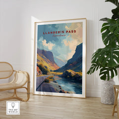 Framed Llanberis Pass Snowdonia travel art print in modern living room with chair and plant.