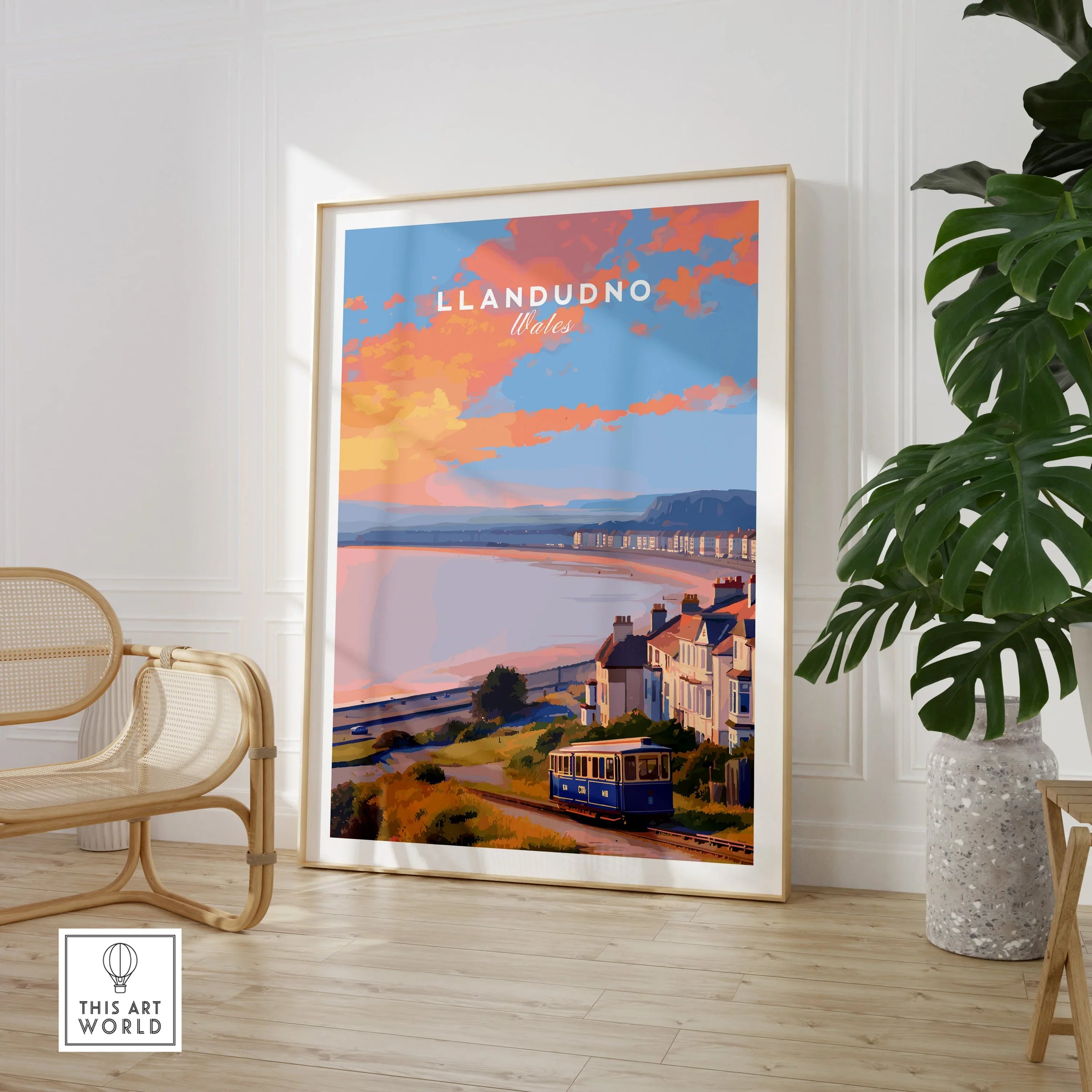 Framed Llandudno Wales travel poster in modern room with chair and plant