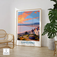 Framed Llandudno travel poster print in bright room with chair and green plant