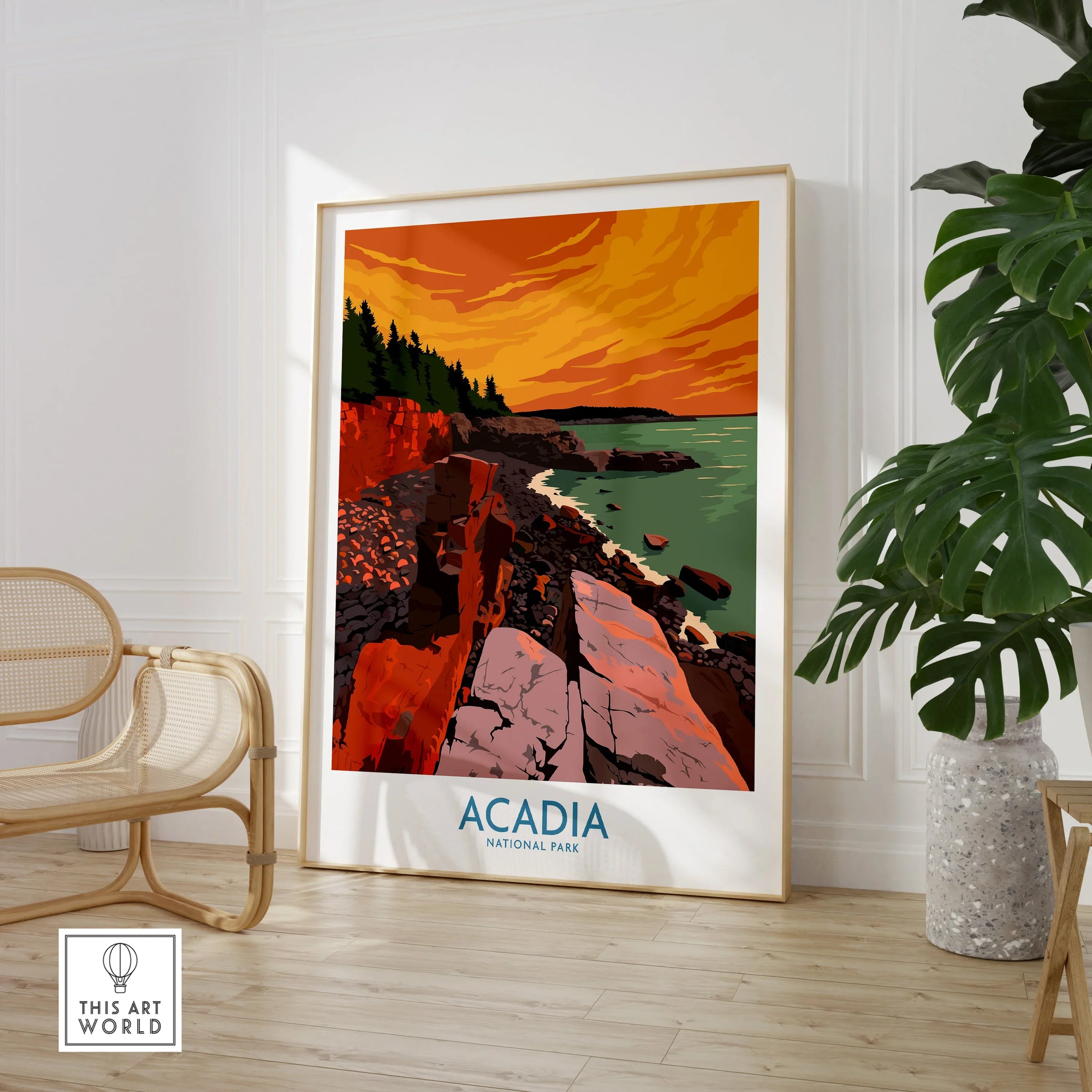 Acadia National Park travel poster in frame by chair and plant, vibrant sunset landscape art