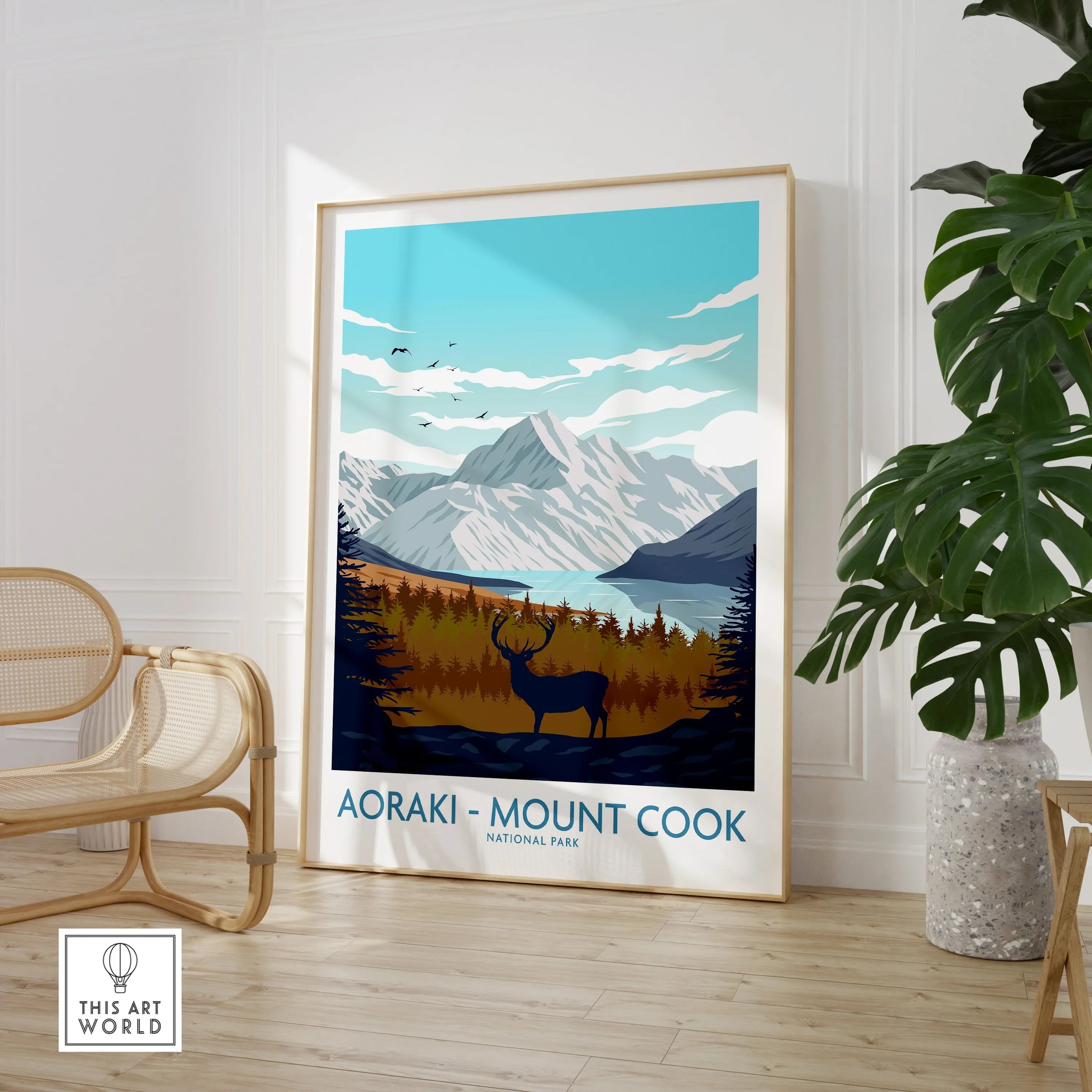 Aoraki Mount Cook National Park travel poster framed in a modern room with chair and plant.