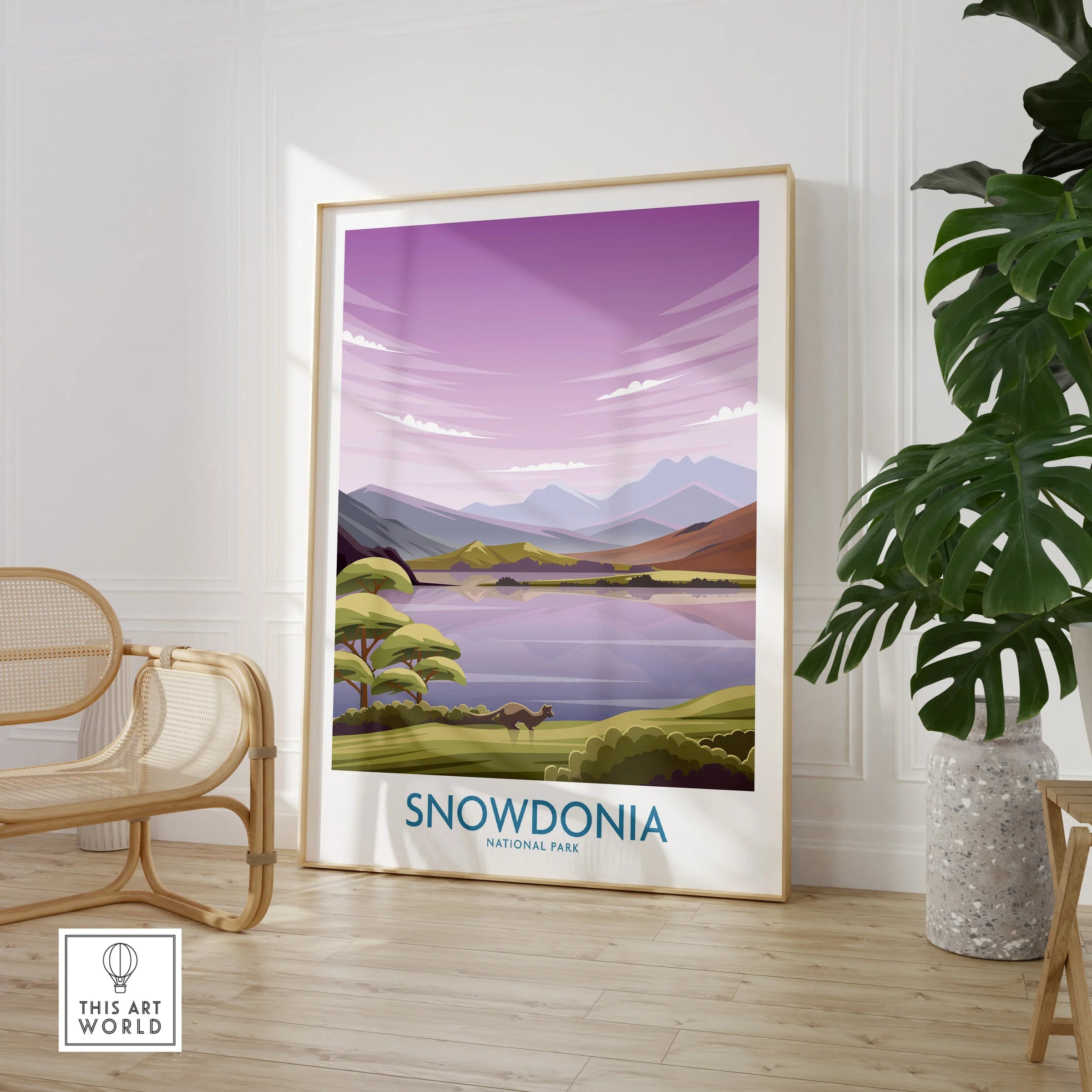 Framed Snowdonia National Park travel poster with mountain landscape, in modern room with chair and plant