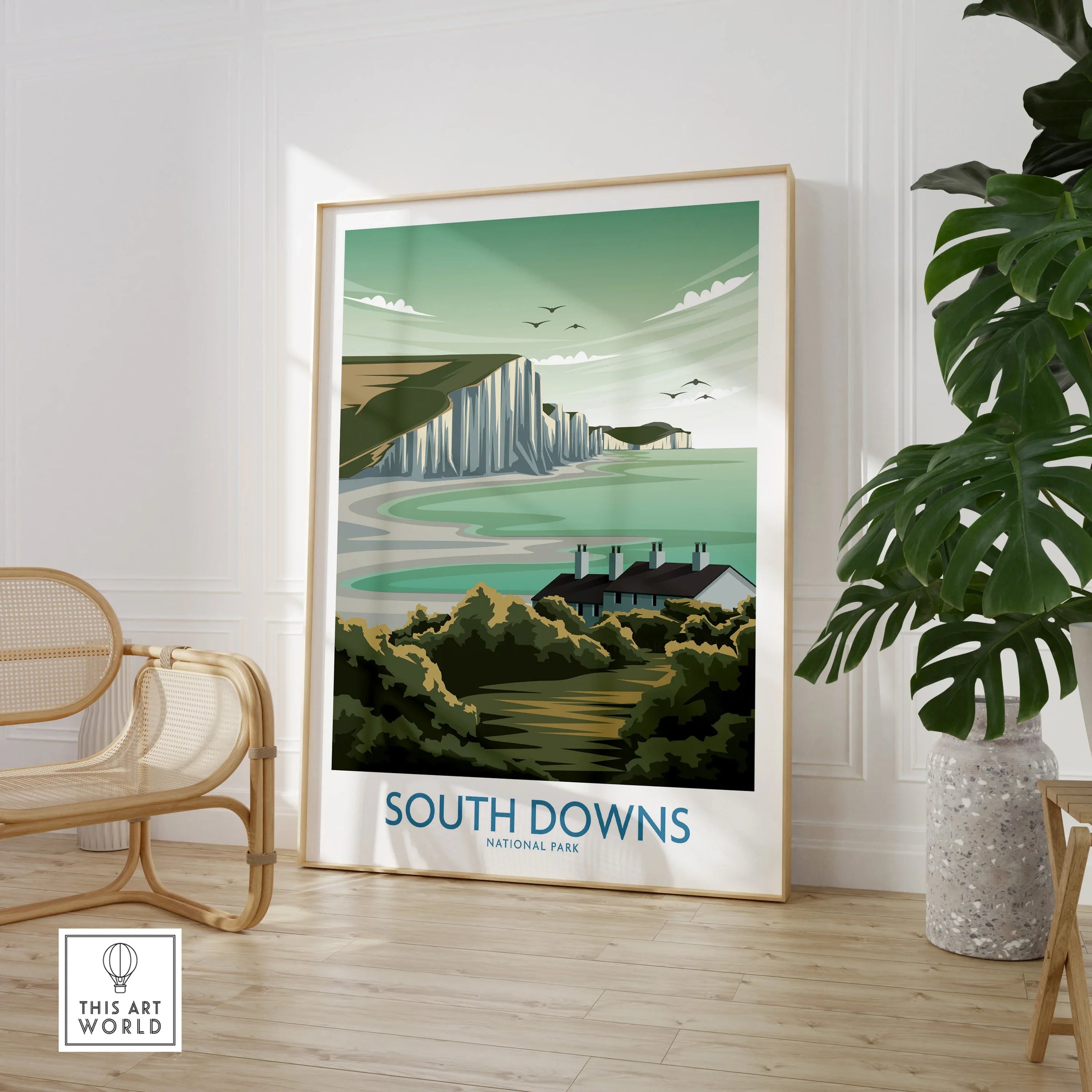 Framed South Downs National Park travel poster print in modern room with chair and plant.