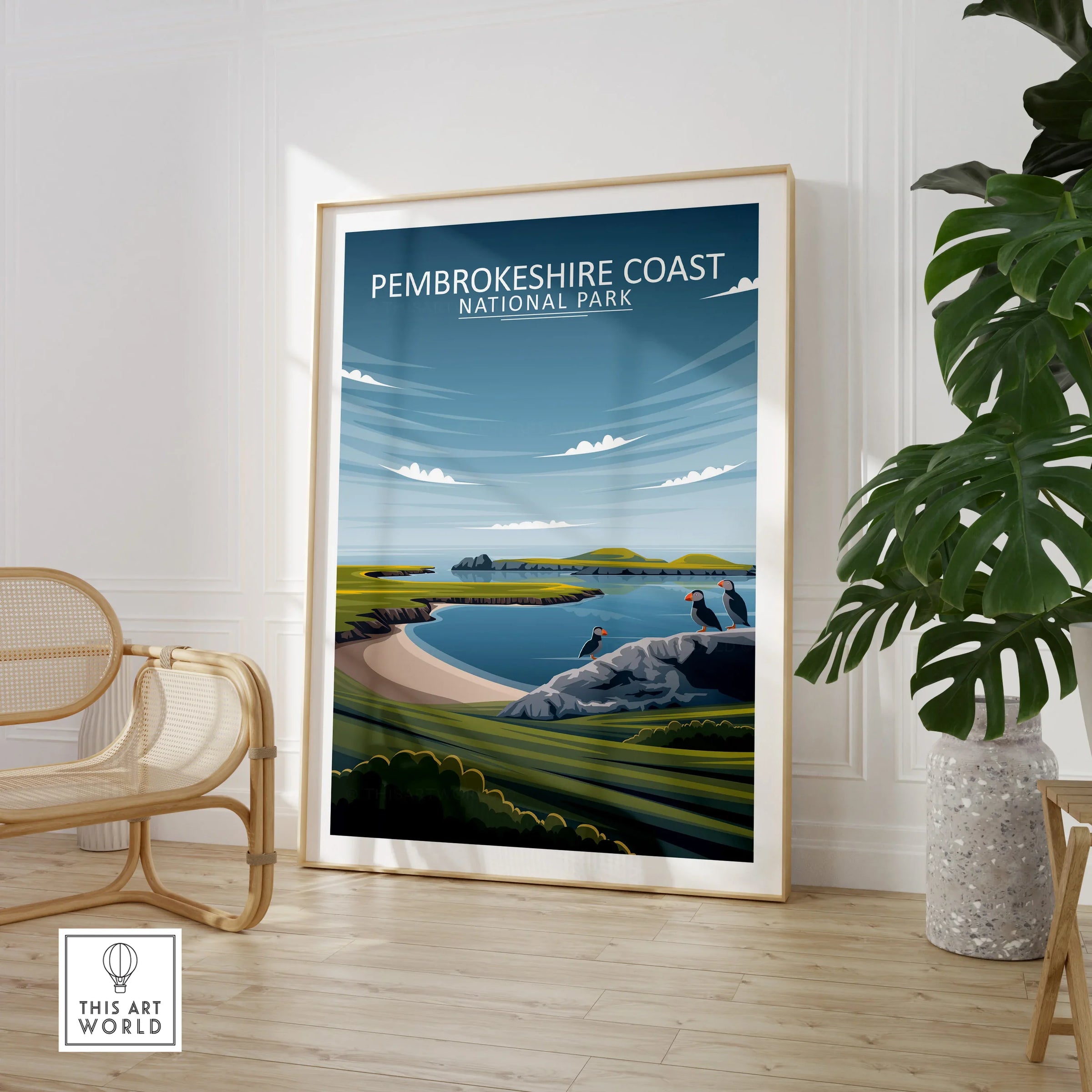 Pembrokeshire Coast National Park travel poster framed on floor, modern room with chair and plant