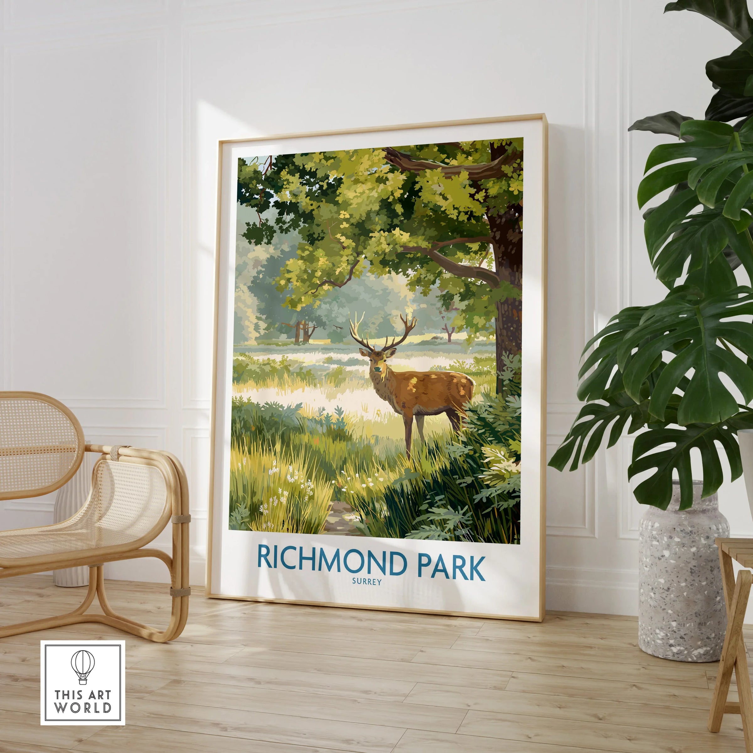 Framed Richmond Park travel poster with deer, beside plant and chair in modern room