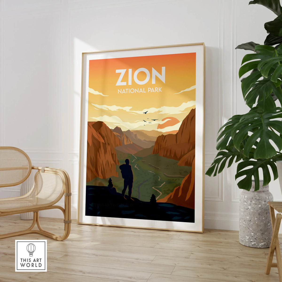 Framed Zion National Park travel poster on wall by chair and potted plant in modern room