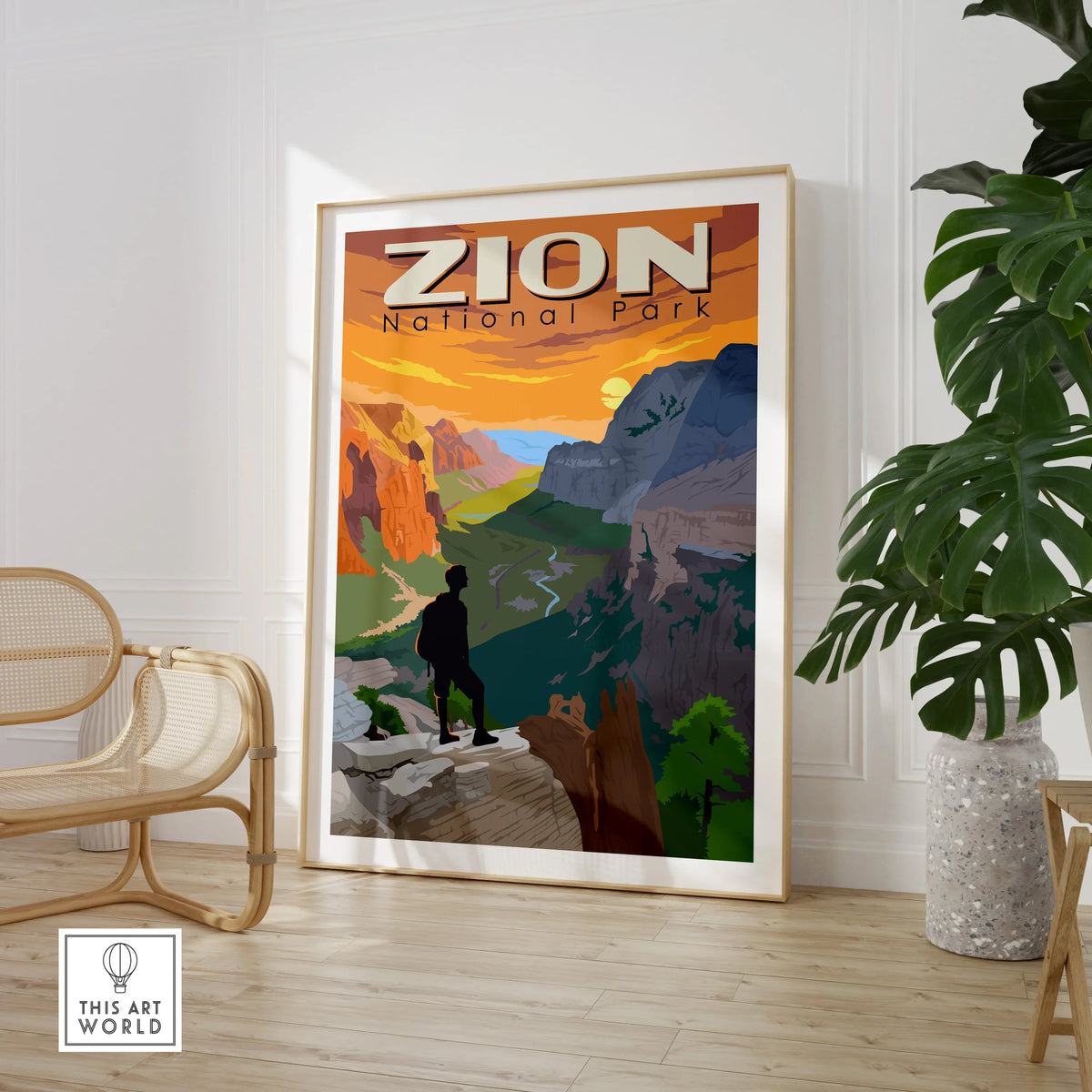 Framed Zion National Park travel poster print in modern living room with chair and plant.