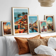Set of five framed travel art prints including Accra Ghana coastal village above a bed