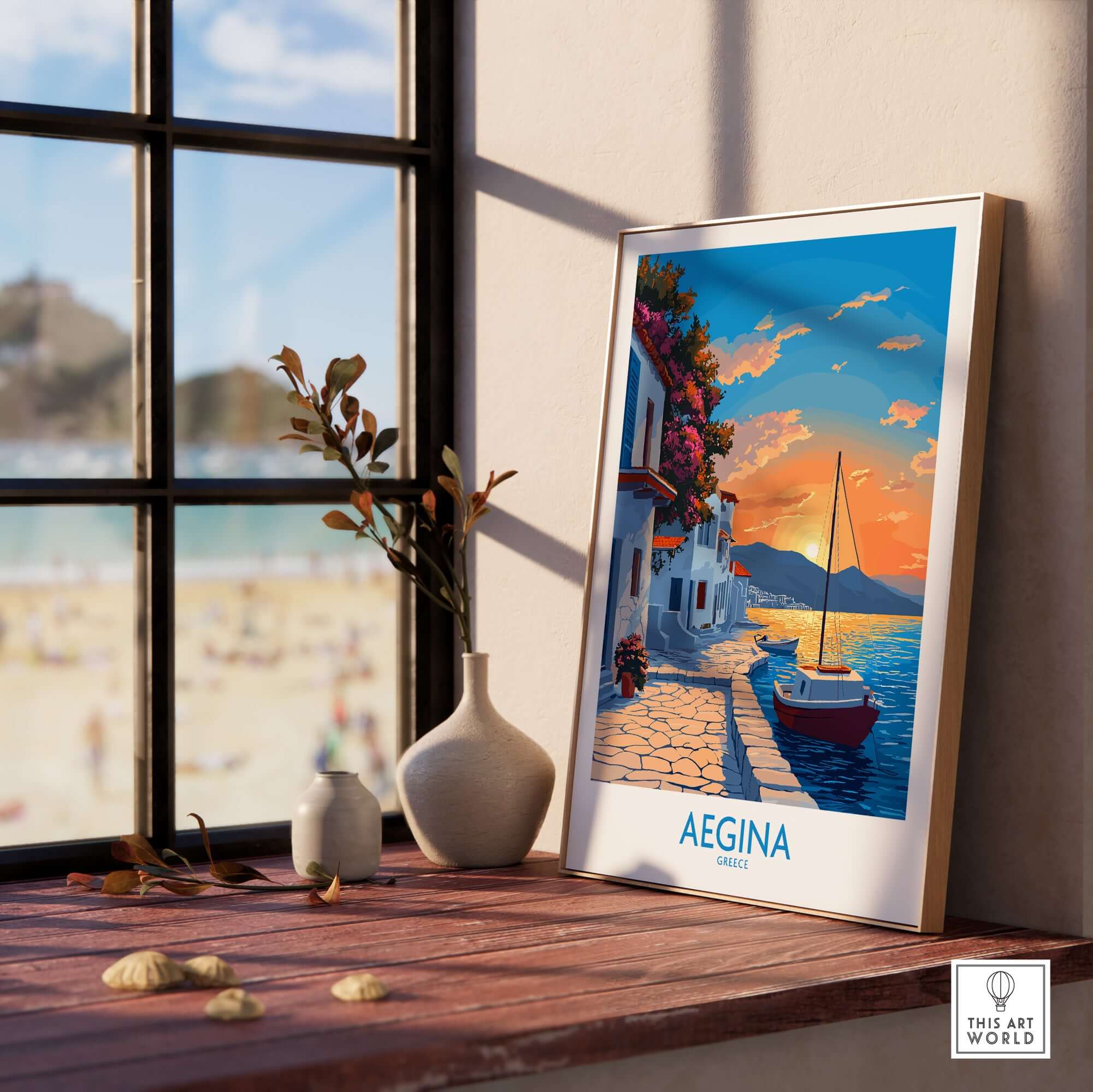 Aegina Greece Travel Poster displayed on a shelf with a sunset view and a boat in the background.