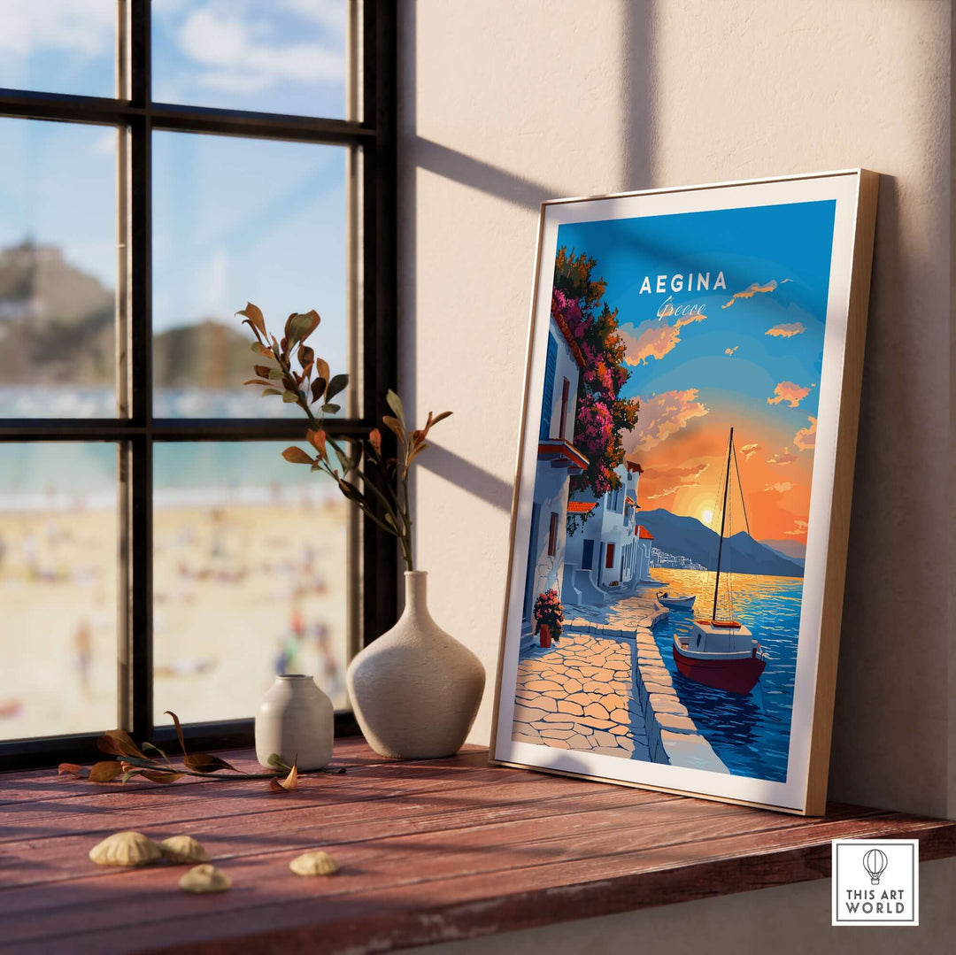 Aegina Greece travel print displayed by a window, showcasing a vibrant sunset and a serene coastal scene.