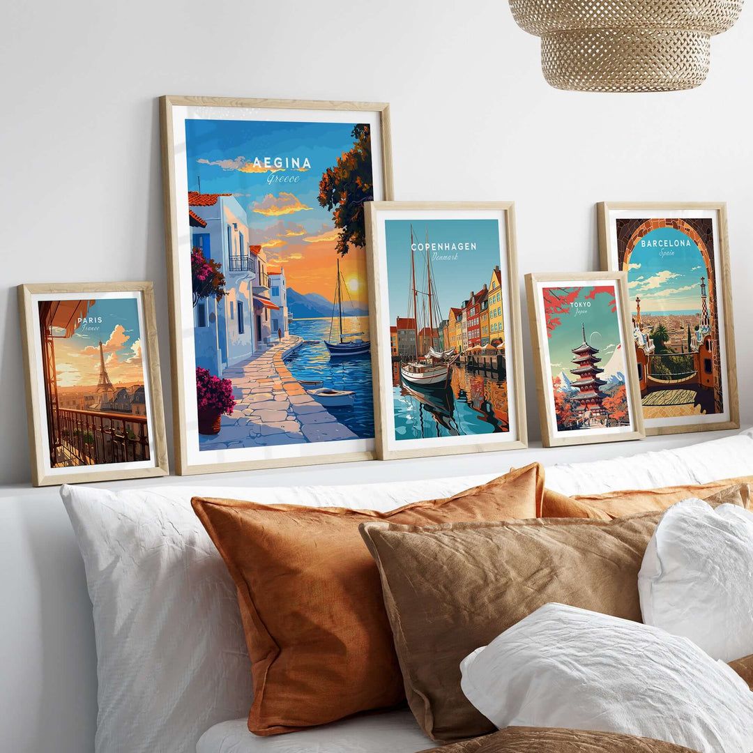 Aegina Travel Print showcasing the Greek island's charm along with other travel prints on a stylish bed setup.