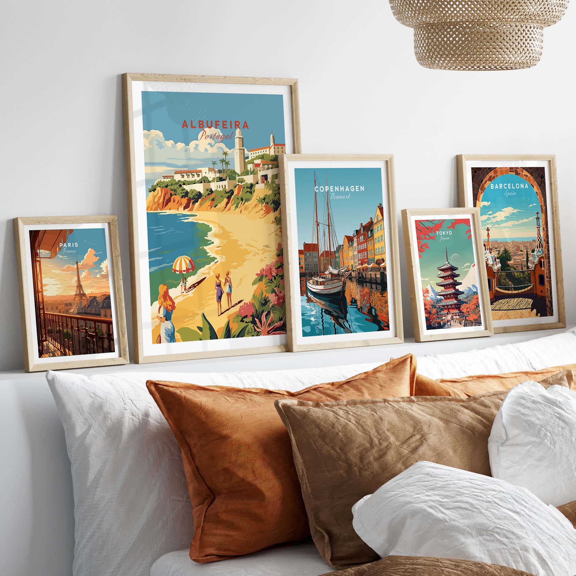 Albufeira Portugal poster displayed among framed travel art prints on a stylish bed with cushions.