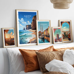 Algarve Print Beach Poster displayed among travel posters on a stylish bed with decorative cushions.
