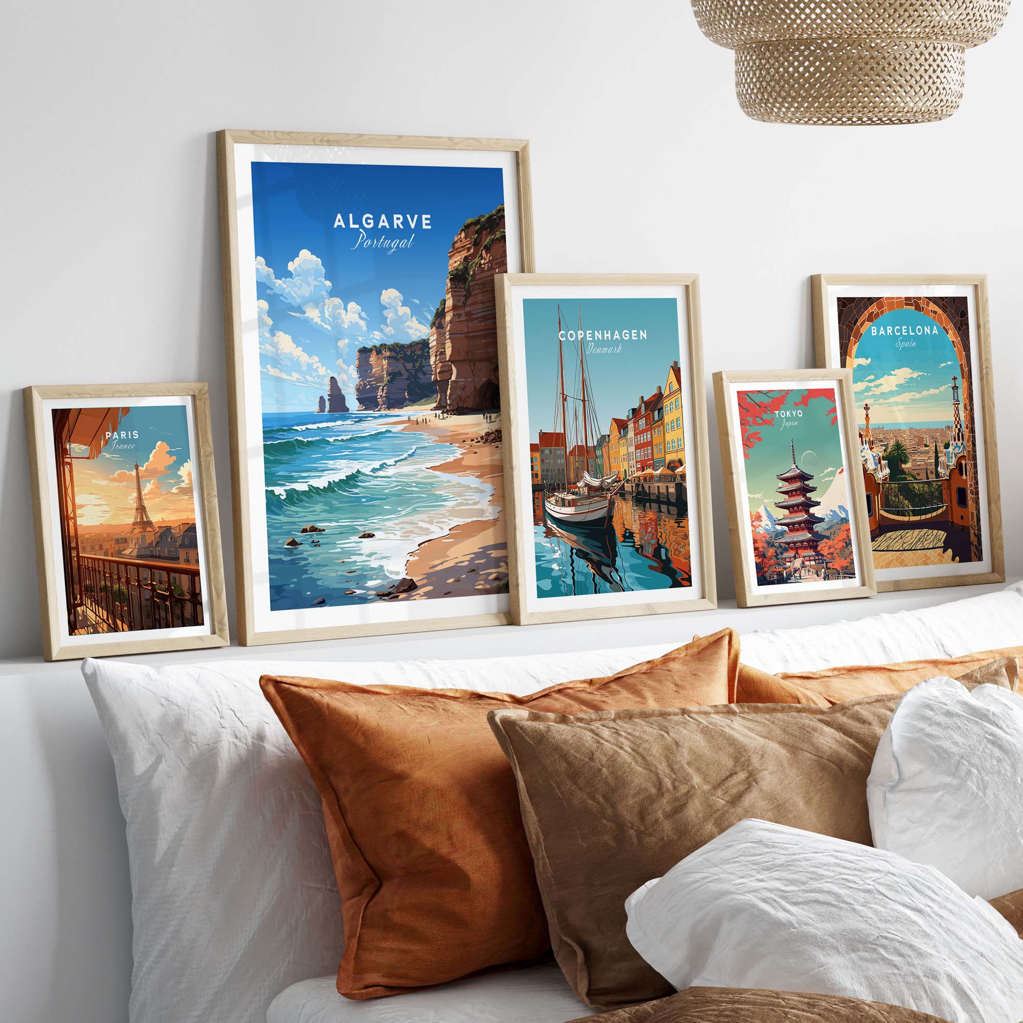 Algarve Print Beach Poster displayed among travel posters on a stylish bed with decorative cushions.