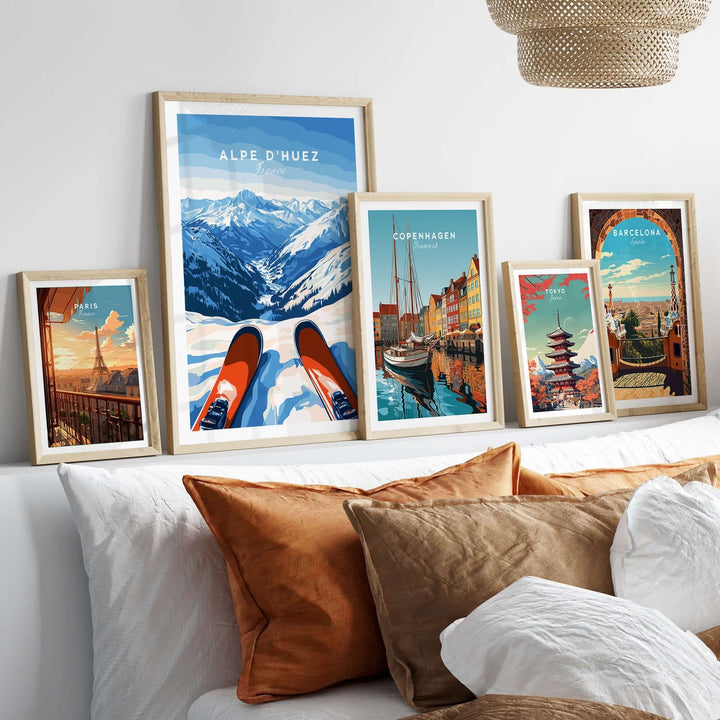 Alpe d'Huez wall art displayed with other travel posters on a cozy sofa, showcasing stunning mountain landscapes and vibrant colors.