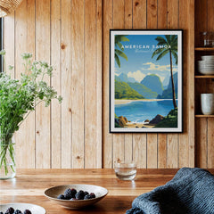 American Samoa National Park travel poster art print in black frame, displayed in rustic kitchen setting with wood panel walls, vase of flowers, and bowls of berries on wooden table.
