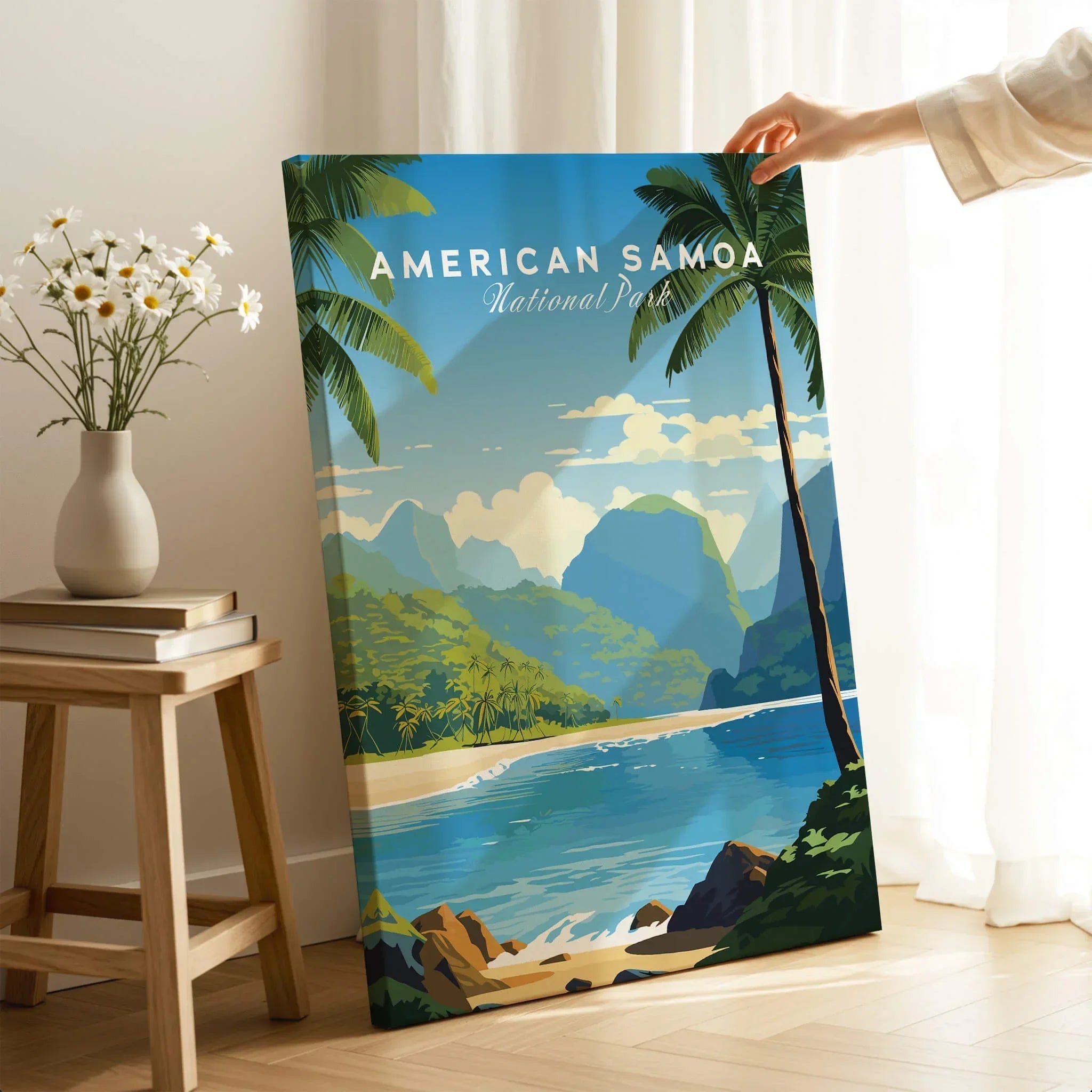 Hand holding American Samoa National Park travel poster with beach and palm trees in bright room