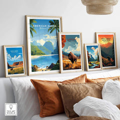 Framed national park travel posters with landscape art above a modern sofa with pillows.