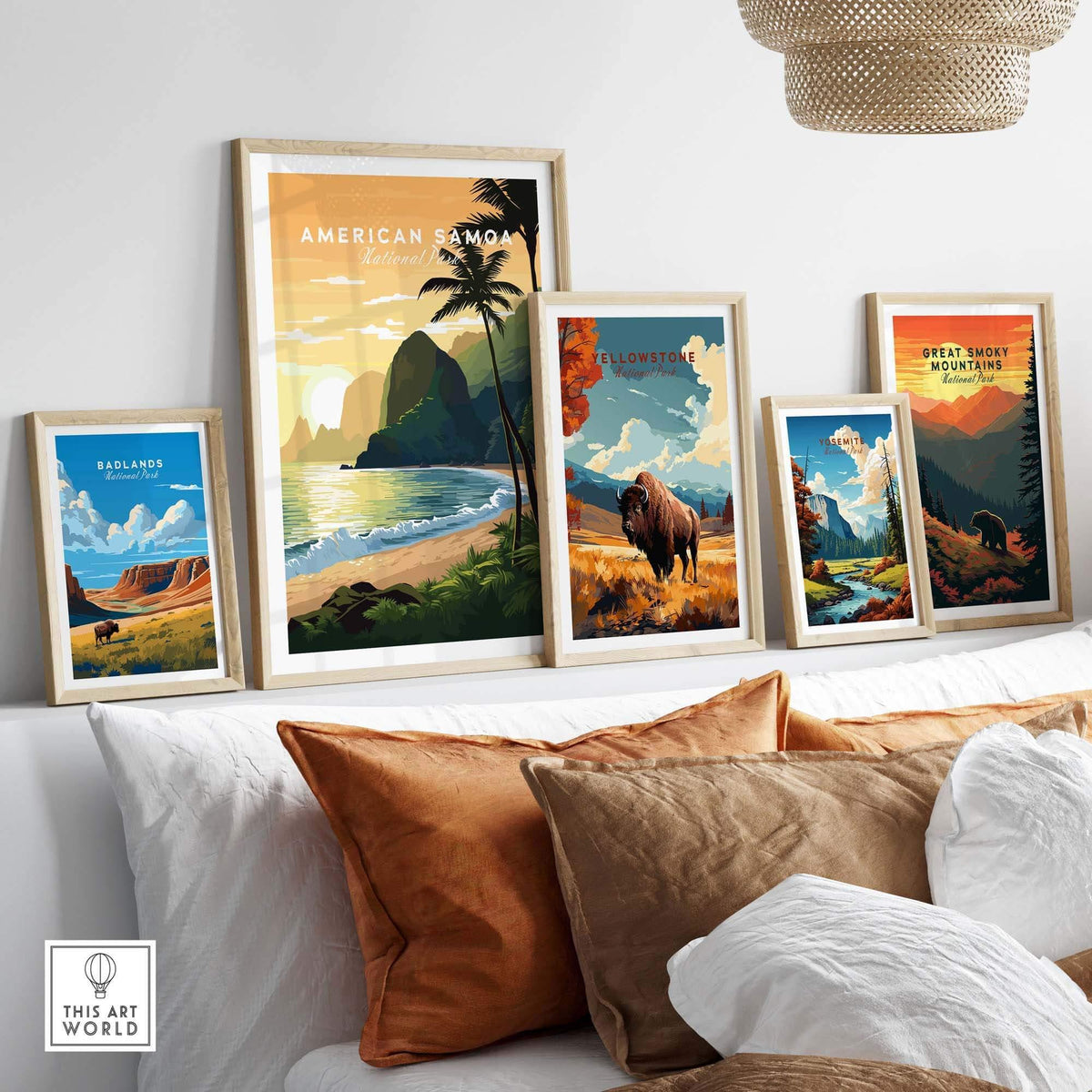 Framed travel posters of American Samoa, Yellowstone, Yosemite, Badlands, and Great Smoky Mountains National Parks displayed above a modern sofa with brown and white pillows.