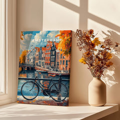 Colorful Amsterdam Canal House Poster - Classic Dutch Canal Scene Print on display with a bicycle and flowers.