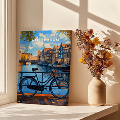 Colourful Amsterdam Architecture Poster - Iconic Canal Houses and Canals Wall Art displayed near a window with a bicycle.