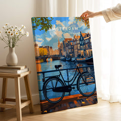 Colourful Amsterdam Architecture Poster - Iconic Canal Houses and Canals Wall Art on display with a bike in front of a canal.