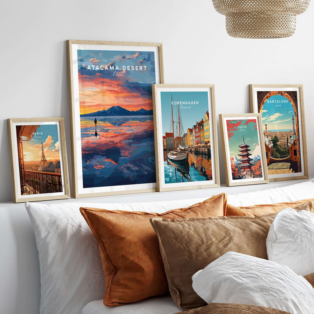 Atacama Desert wall art poster displayed among framed travel prints on a stylish bed with decorative pillows.