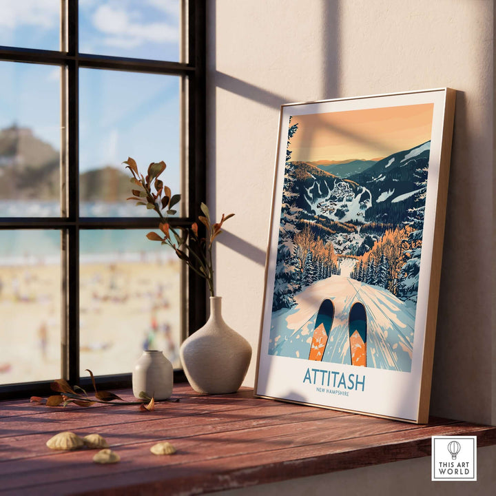 Attitash Ski Art Print displayed on a windowsill, showcasing a ski scene with mountains and a scenic landscape in warm tones.