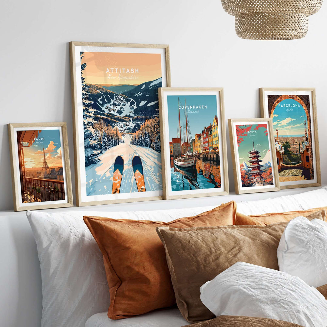 Collection of framed travel and ski wall art posters, including Attitash, displayed above a cozy bed with decorative pillows.