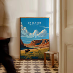 Framed Badlands National Park travel poster with bison art leaning on floor, man walking by