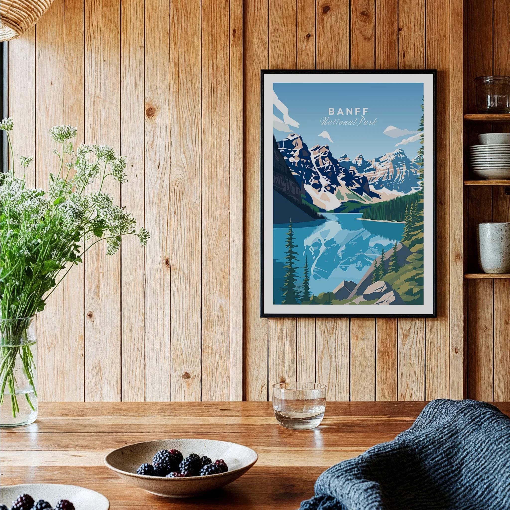 Banff National Park art print in black frame on rustic wood kitchen wall with berries and glassware