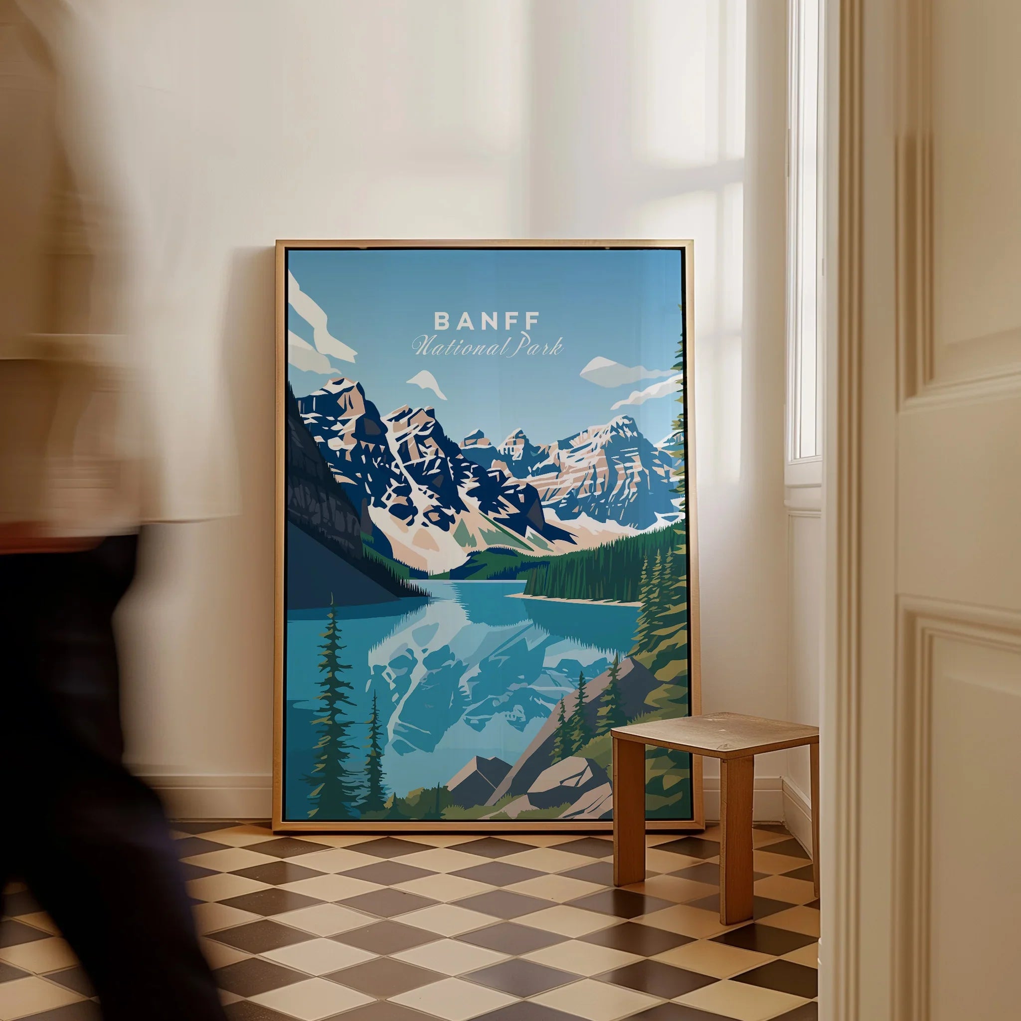 Framed Banff National Park travel poster with mountain and lake artwork in a home entryway.