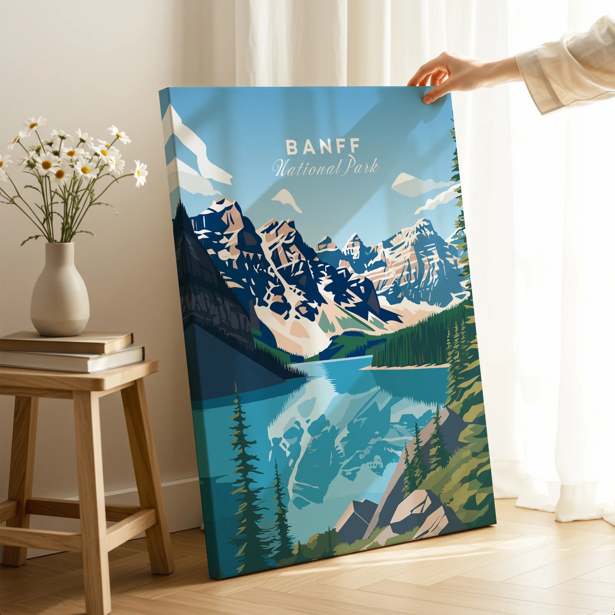 Hand holding Banff National Park canvas print with mountain and lake art in modern room