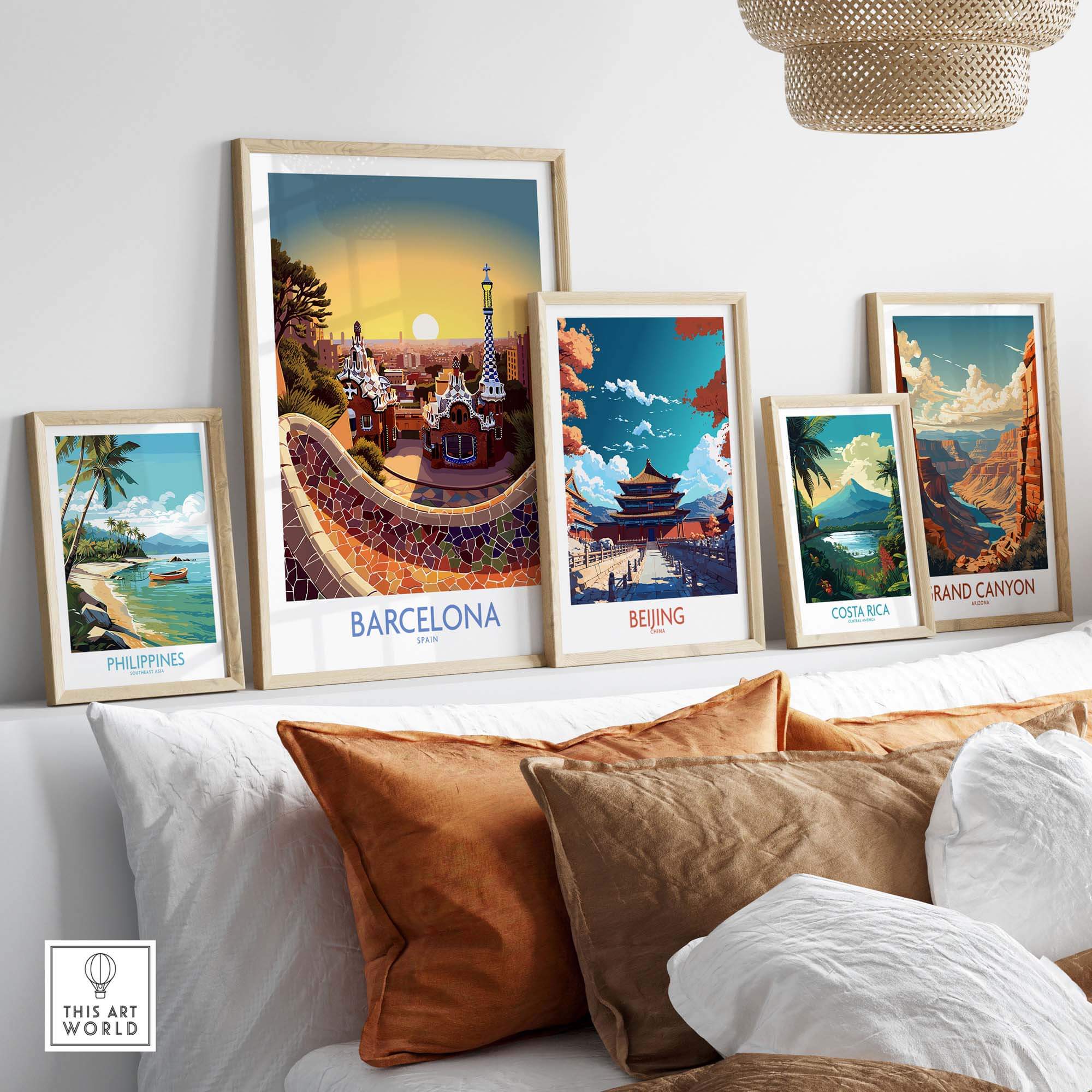 Framed art prints of Barcelona, Beijing, Costa Rica, Philippines, and Grand Canyon displayed on a modern sofa.